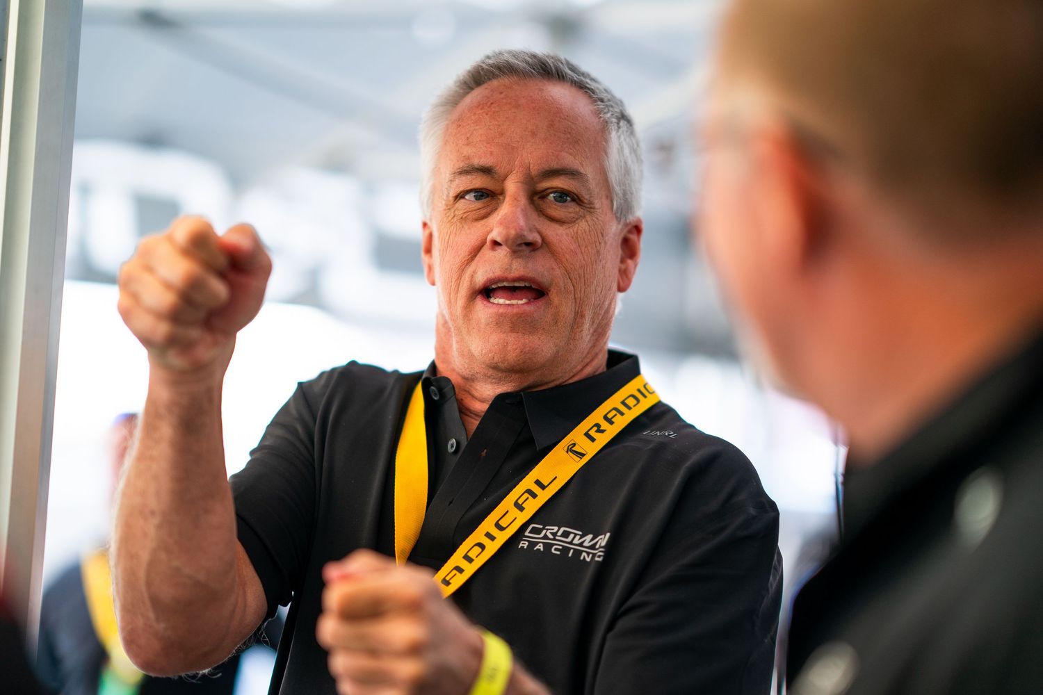 Team members engaged in discussion during a racing event preparation.