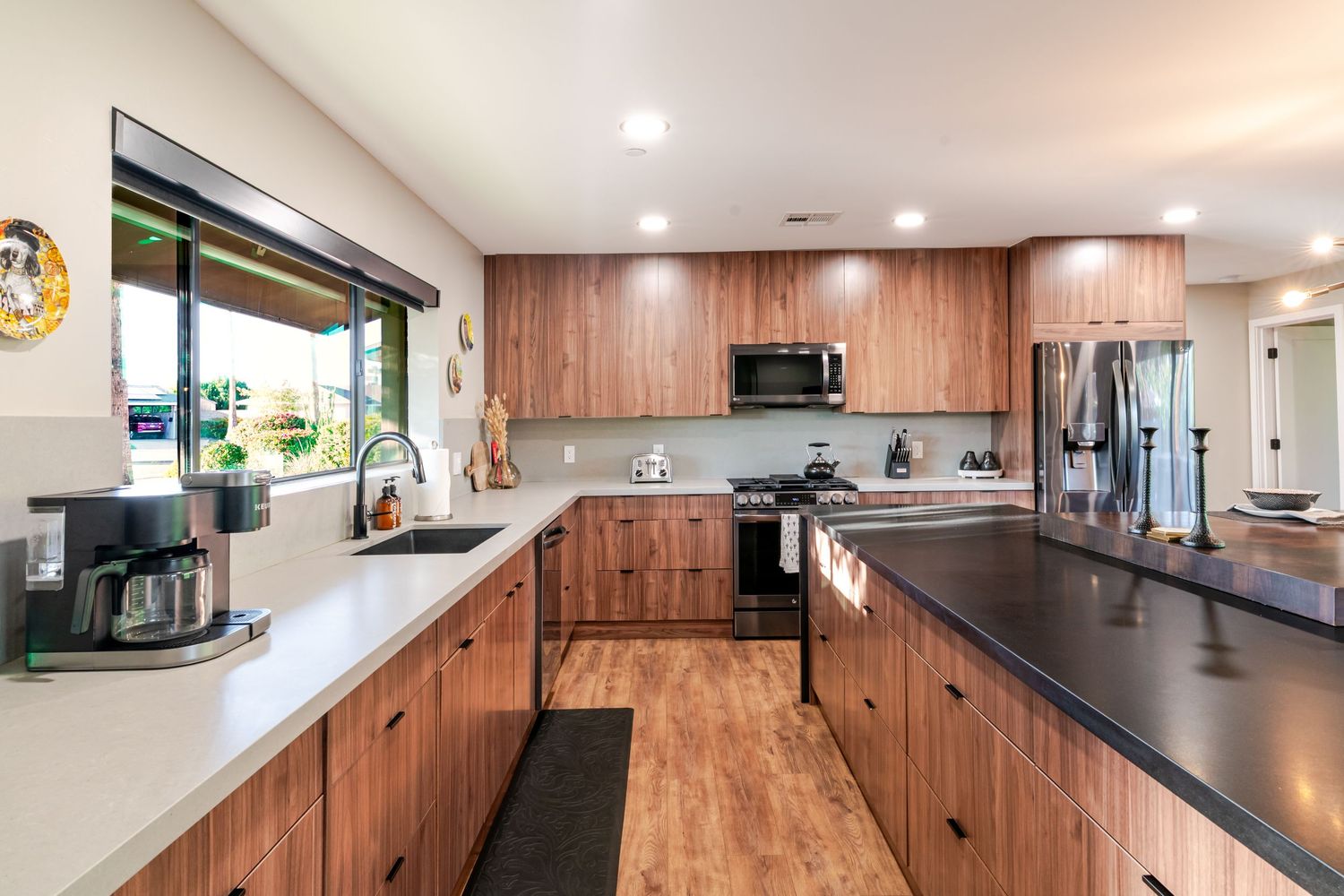 Open concept kitchen with wood paneling, modern appliances and extended breakfast bar counter.