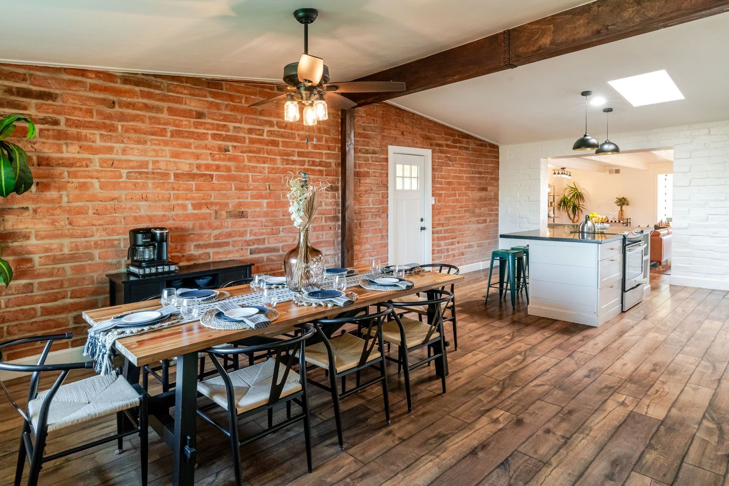 Rustic restaurant interior with exposed brick walls, wooden beams, and industrial-style pendant lighting creates a warm atmosphere.