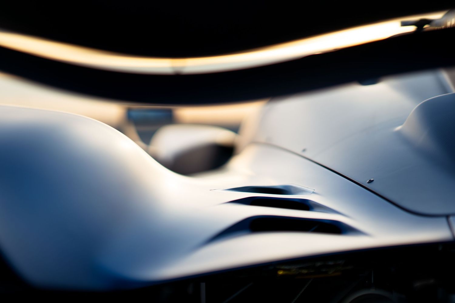 Abstract close-up of sleek curved bodywork on a modern racing car.