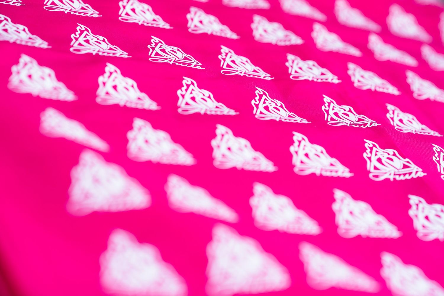 Pink fabric with repeating white ornate triangular pattern printed across the surface.
