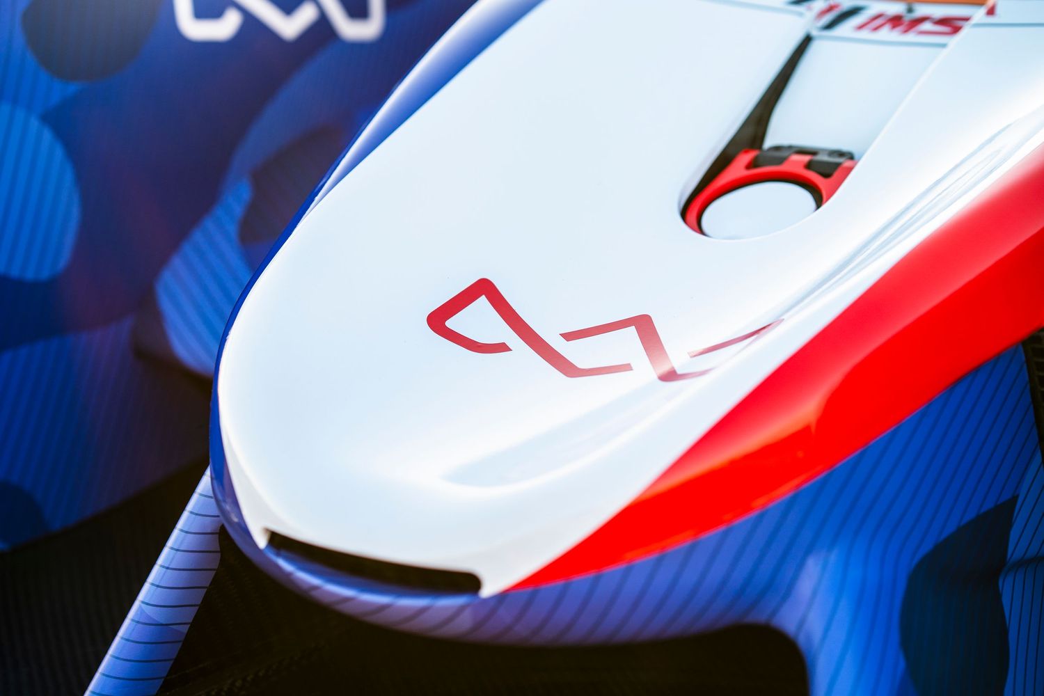 Race car aerodynamic features and wheel details in dramatic lighting.