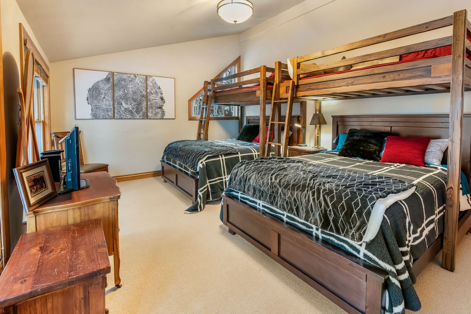 Interior panorama of a cozy cabin bedroom with wooden ceiling, modern furnishings and large windows.