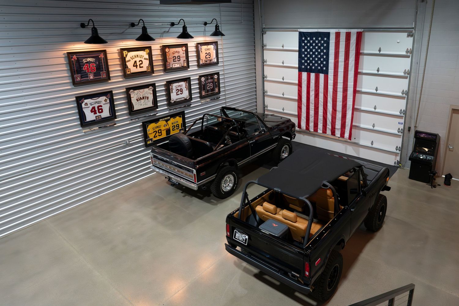 Custom garage featuring classic cars, American flag display, and vintage automotive memorabilia.