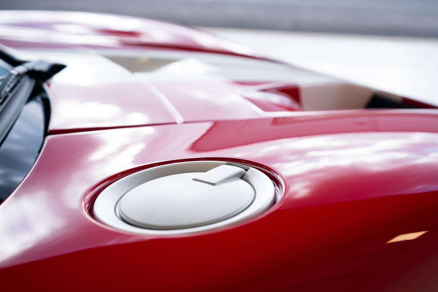 Sleek red automotive bodywork showing smooth curves and reflective paint finish.