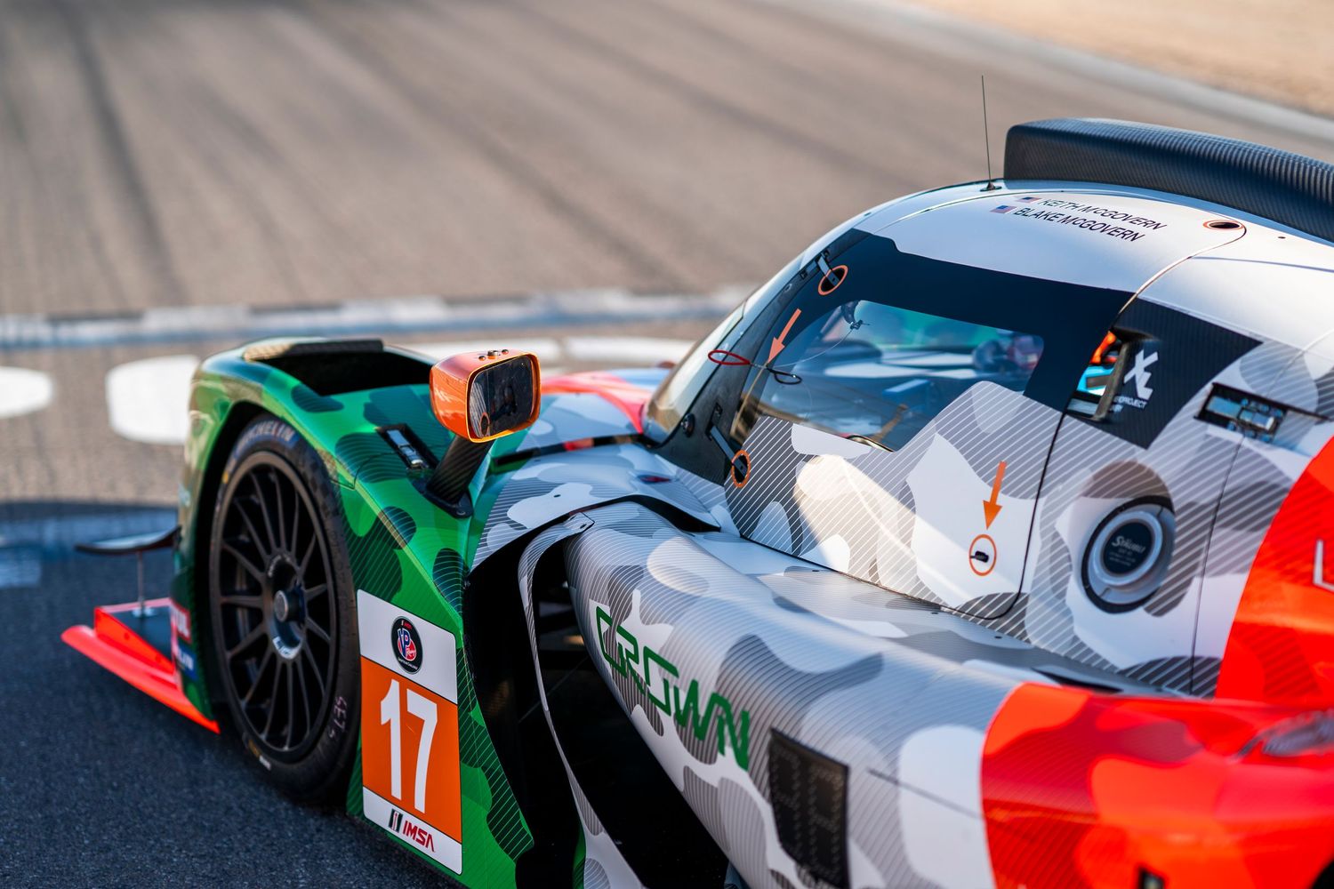 Side view of modern race cars showcasing aerodynamic bodywork and sponsor liveries.