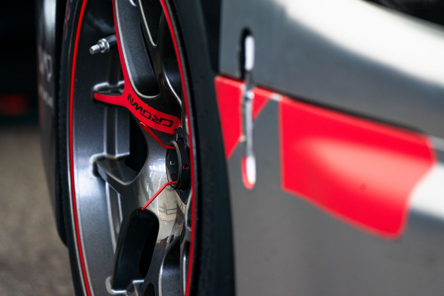 Close-up detail of a red and black race car's aerodynamic component.