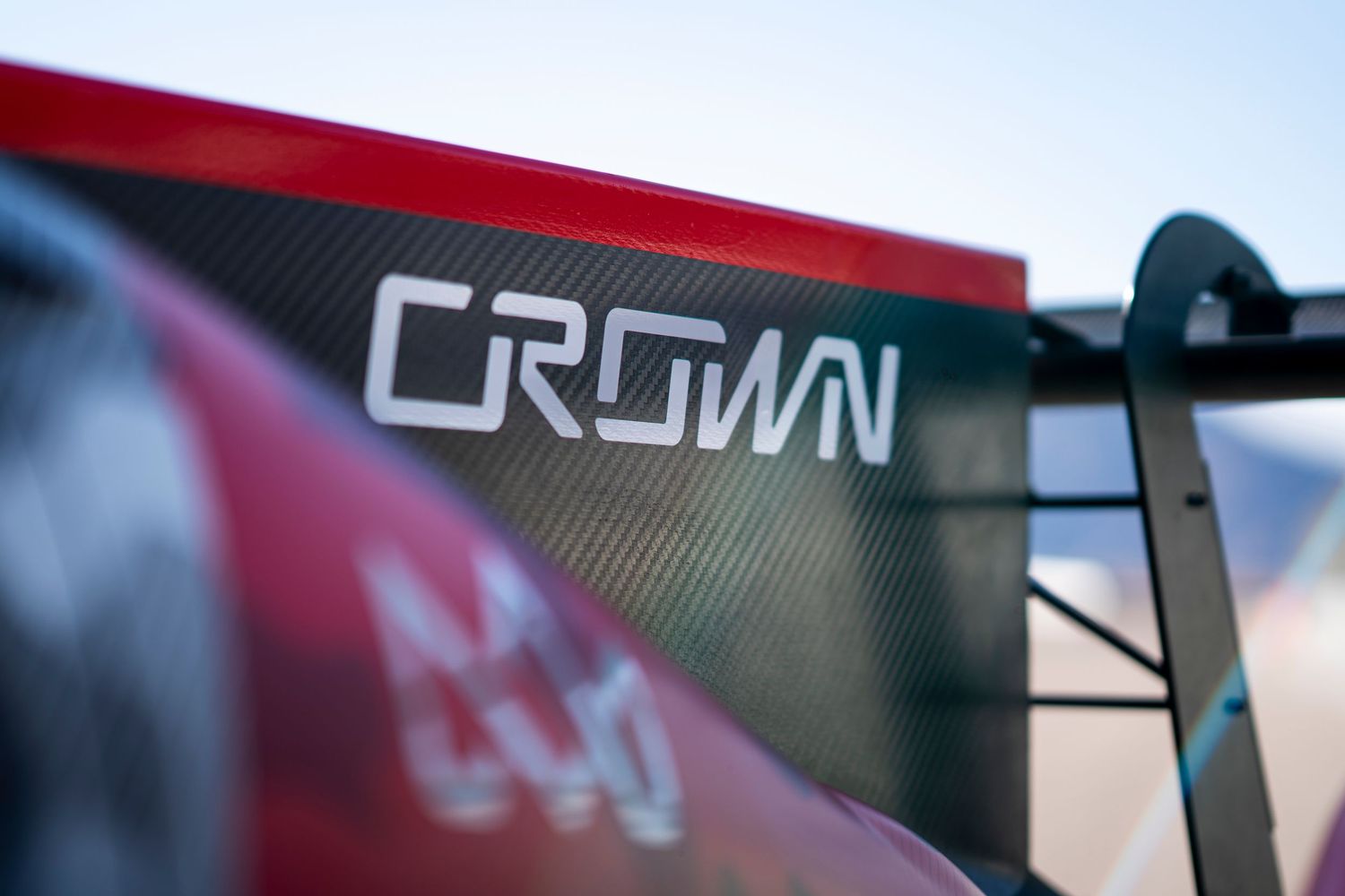 Detail shot of racing car bodywork with Crown branding visible.
