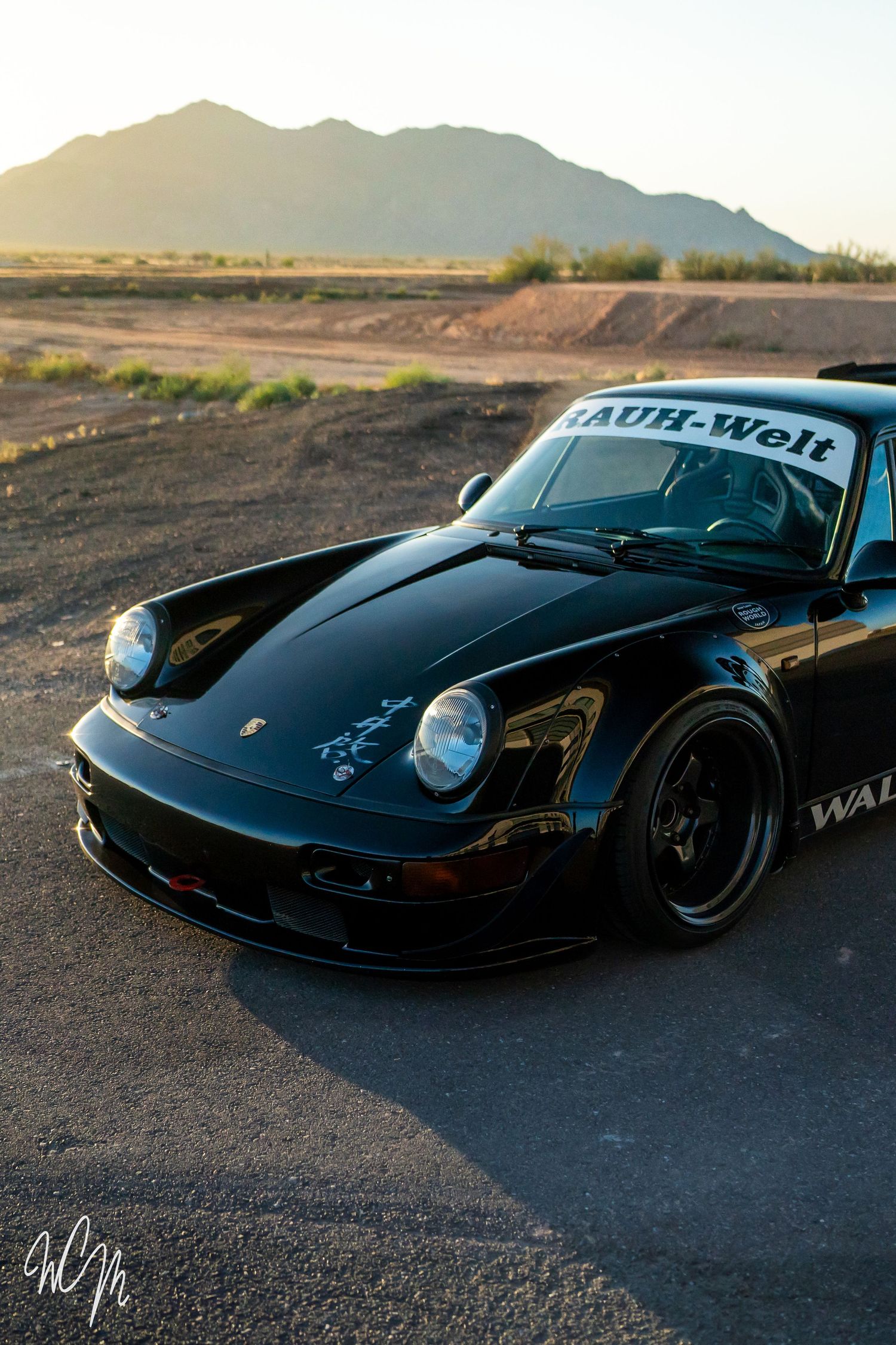Custom Porsche 911 with RWB bodykit photographed in desert landscape at dusk.