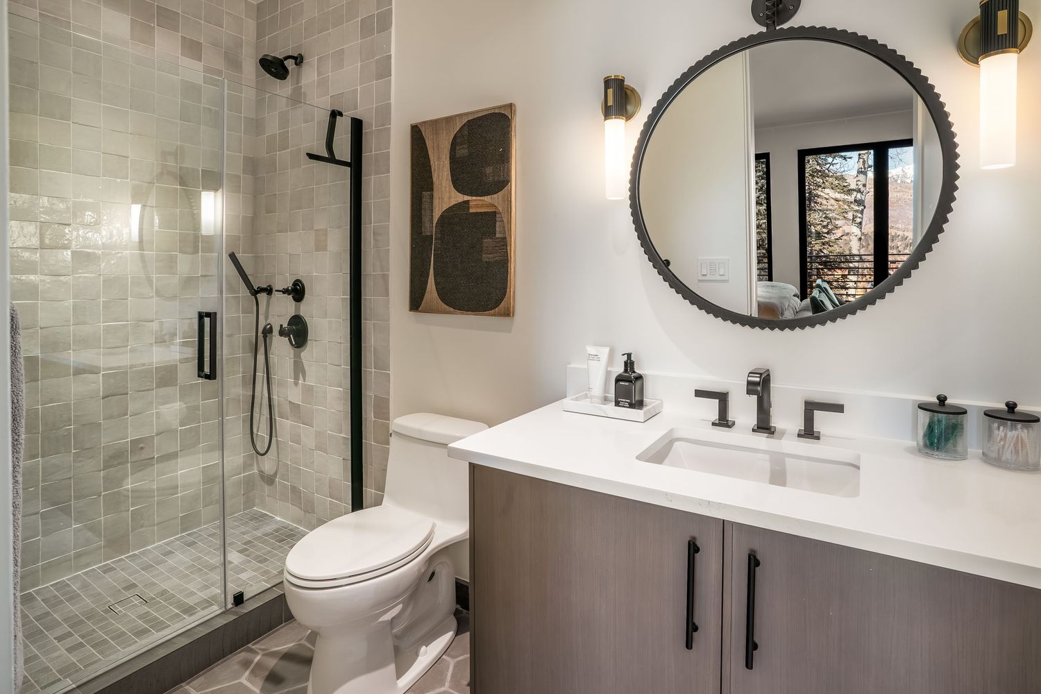 Modern bathroom renovation featuring white subway tile walls, black fixtures, and a glass shower enclosure.
