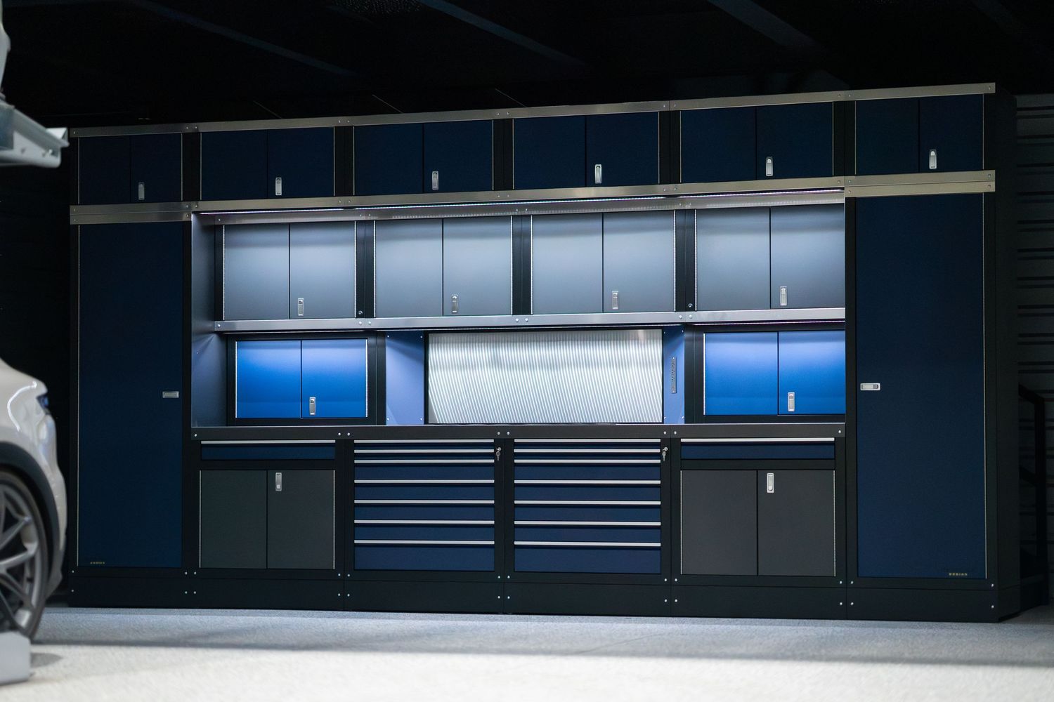 Luxurious white vehicle exhibited in a minimalist industrial garage space with blue accent lighting.
