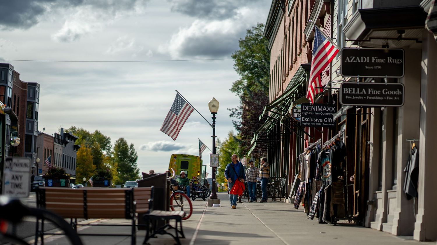 Historic main street with brick buildings and American flags in mountain town.