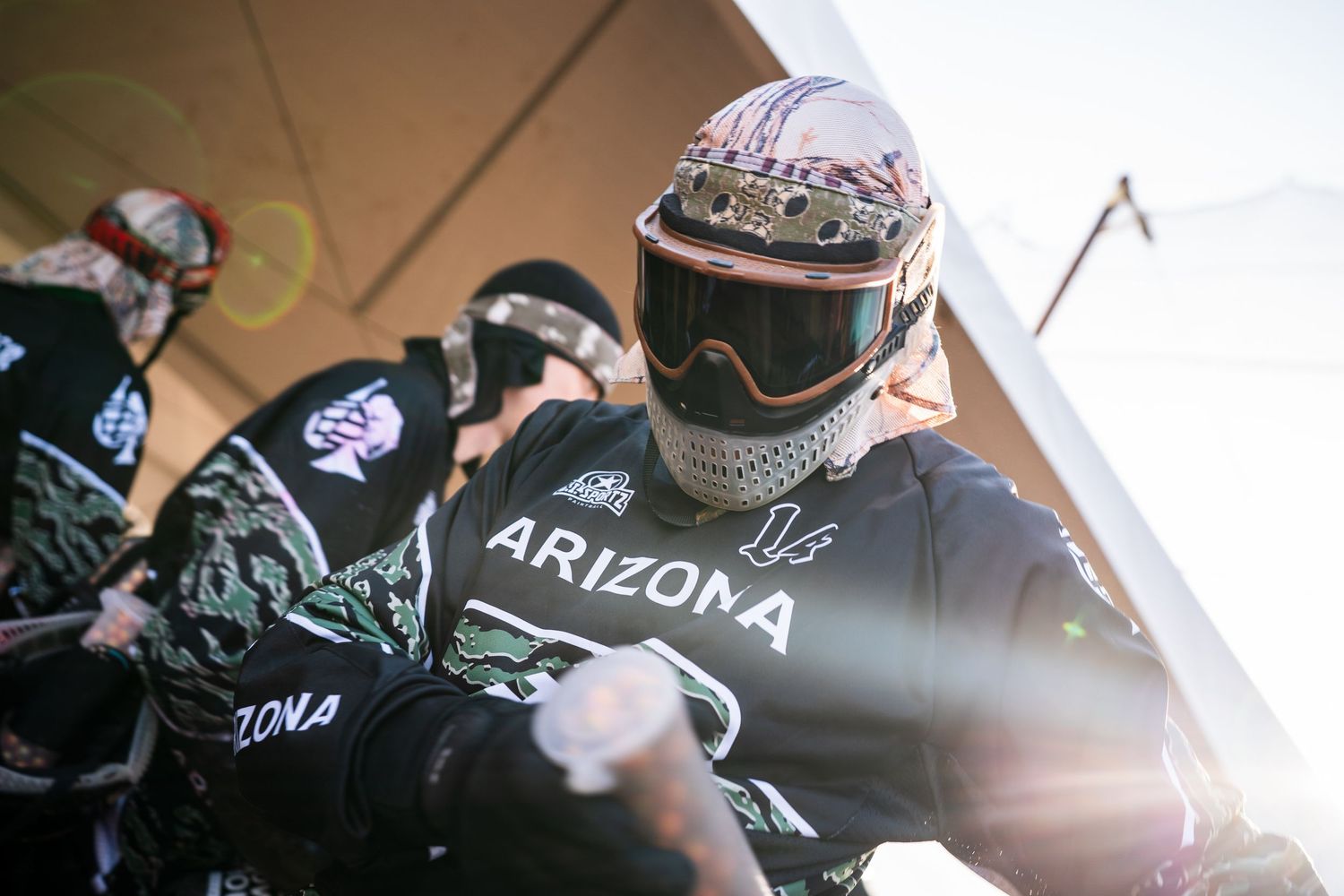 Arizona paintball team player wearing protective helmet and gear prepares for competitive tournament match.