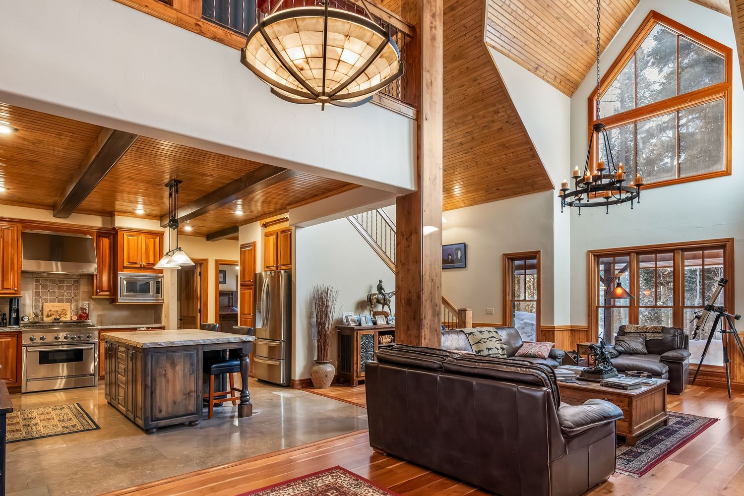 Luxurious mountain lodge interior featuring wood paneling, vaulted ceilings, and rustic decor with modern amenities.