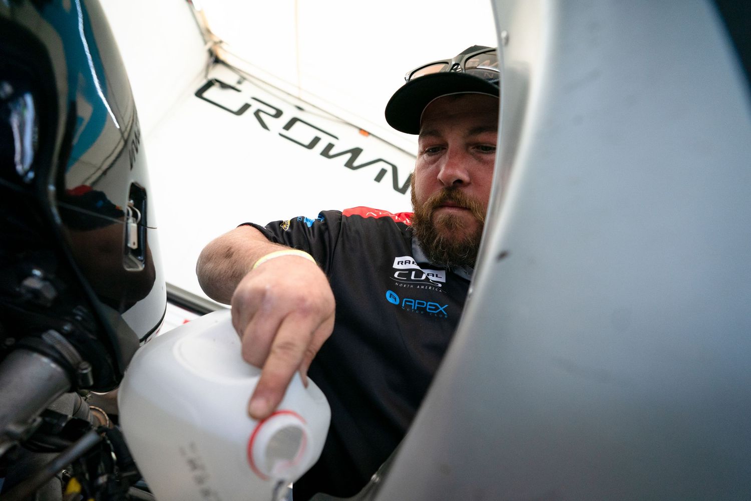 Racing team members reviewing data and making adjustments in the pit garage.