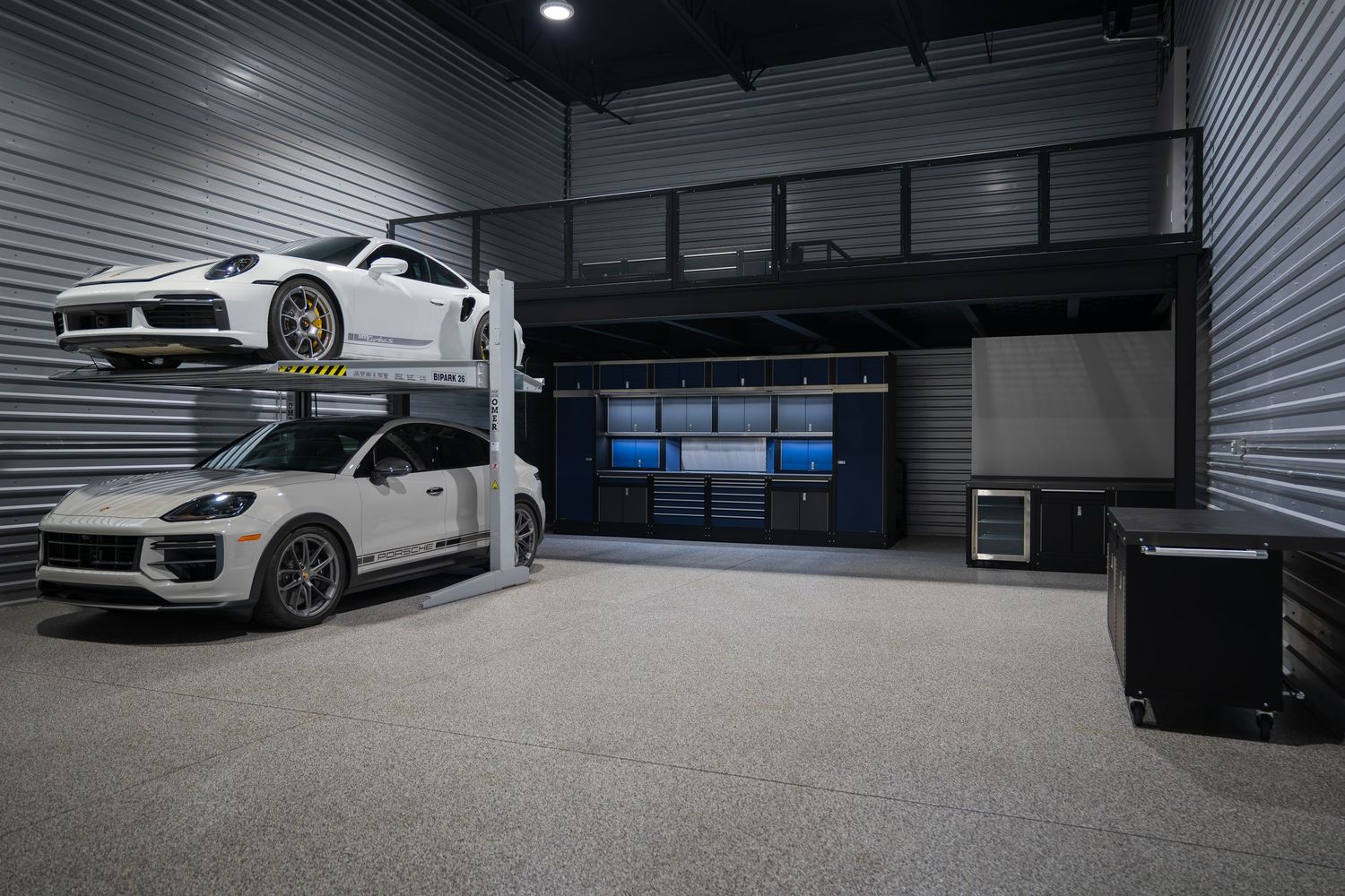 High-end automotive display space featuring white performance vehicles in a sophisticated garage setting.