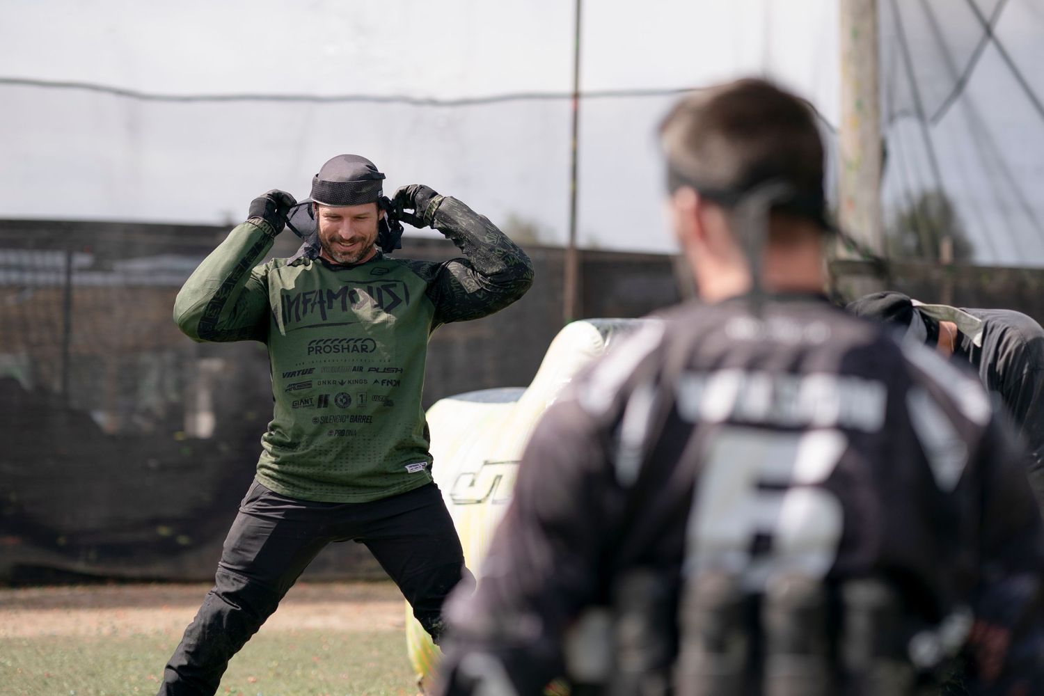 Paintball referee signals during competitive match on field.
