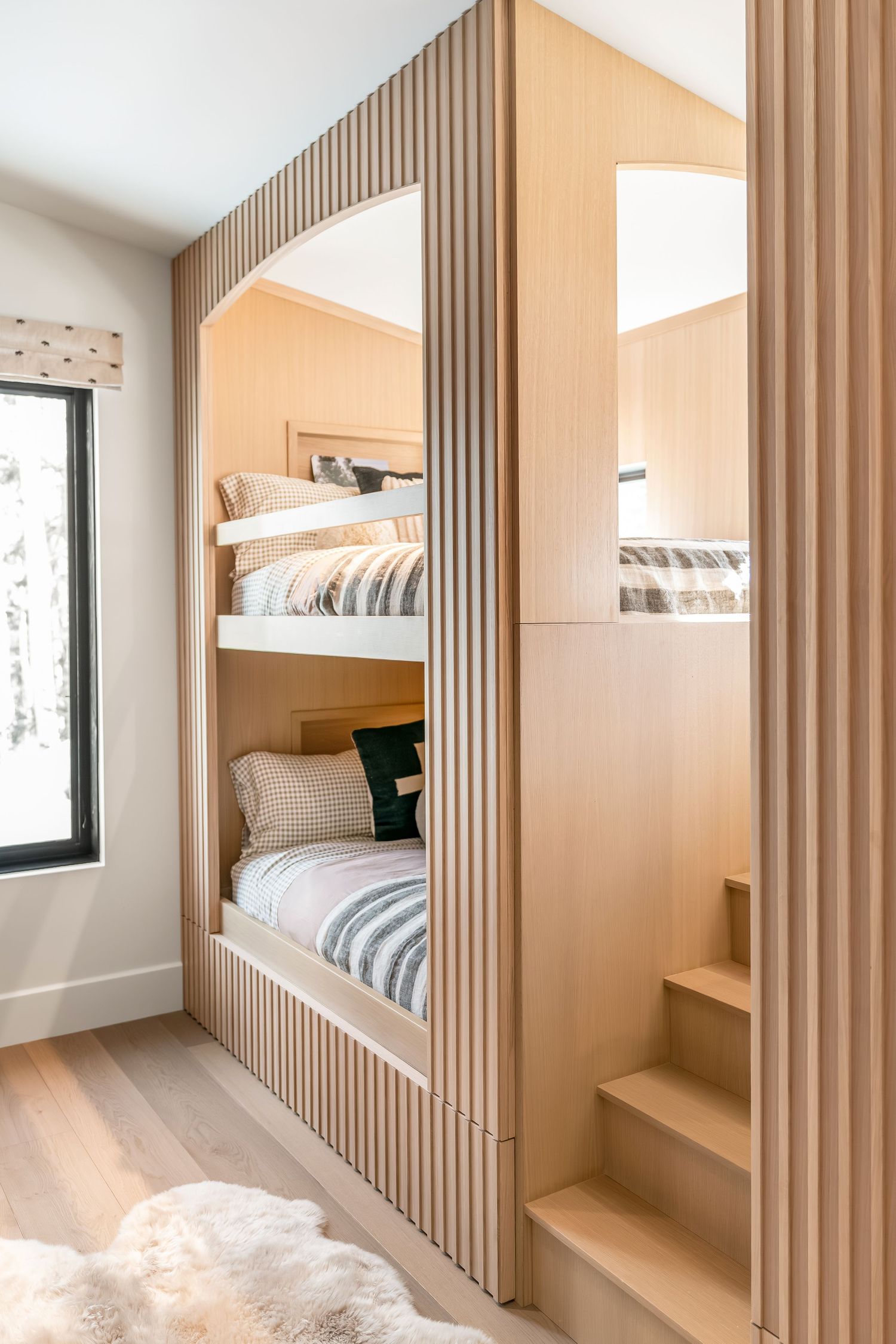 Modern bunk bed room with vertical wood slat wall panels and built-in storage features clean minimalist design.