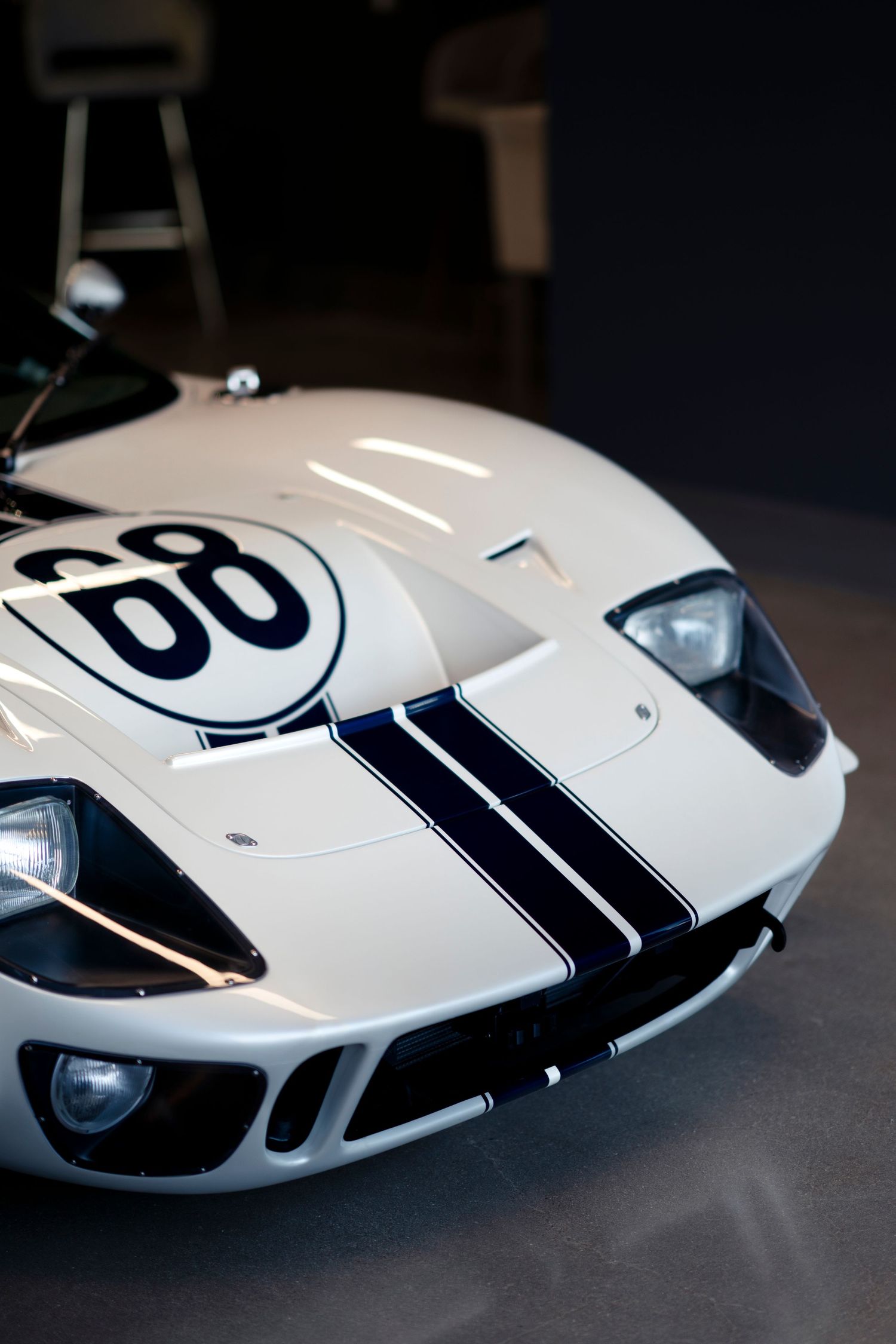 A white Porsche 917 race car with black racing stripes photographed from multiple angles showing its sleek design.