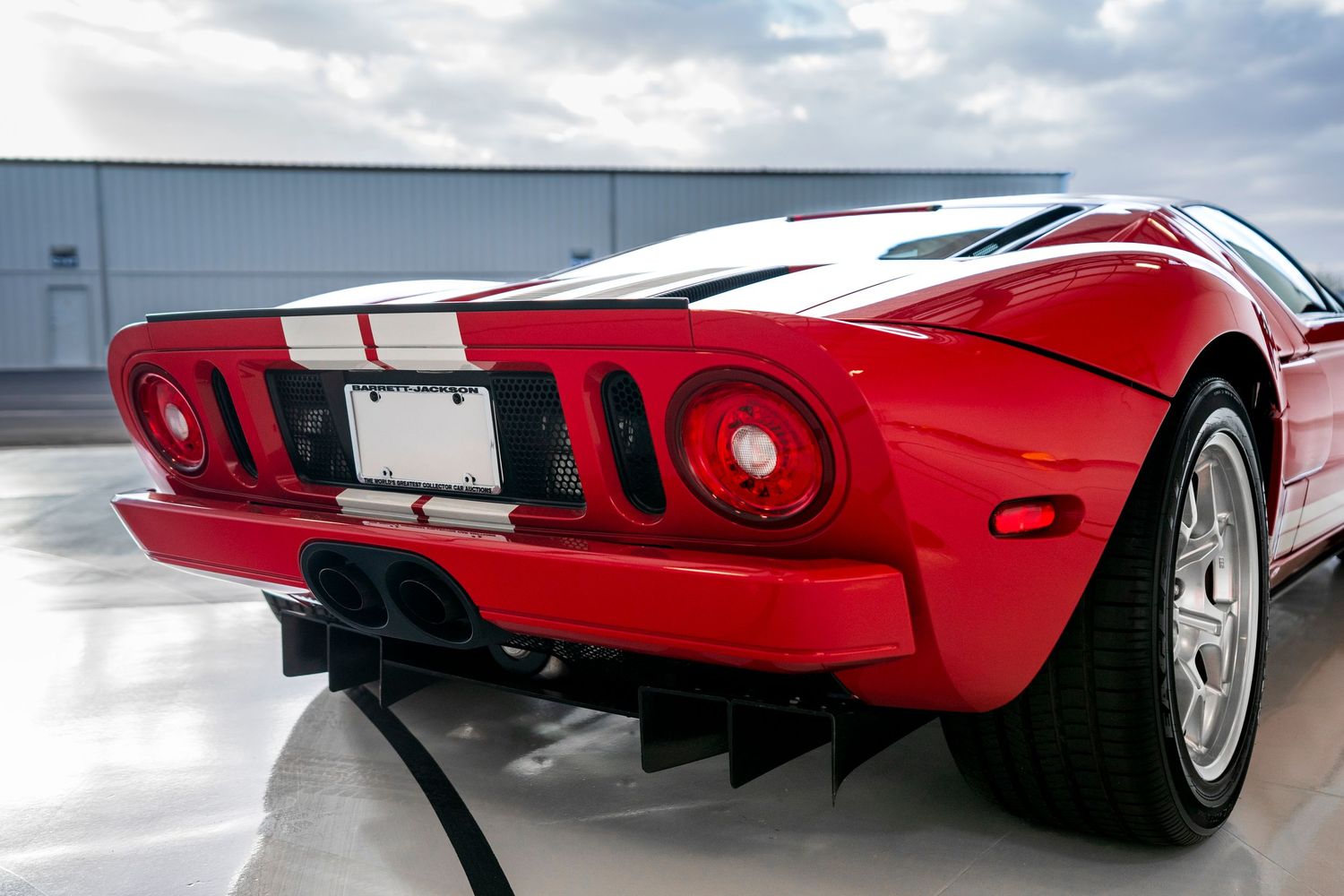Exterior profile views of classic red sports car with white racing stripes.