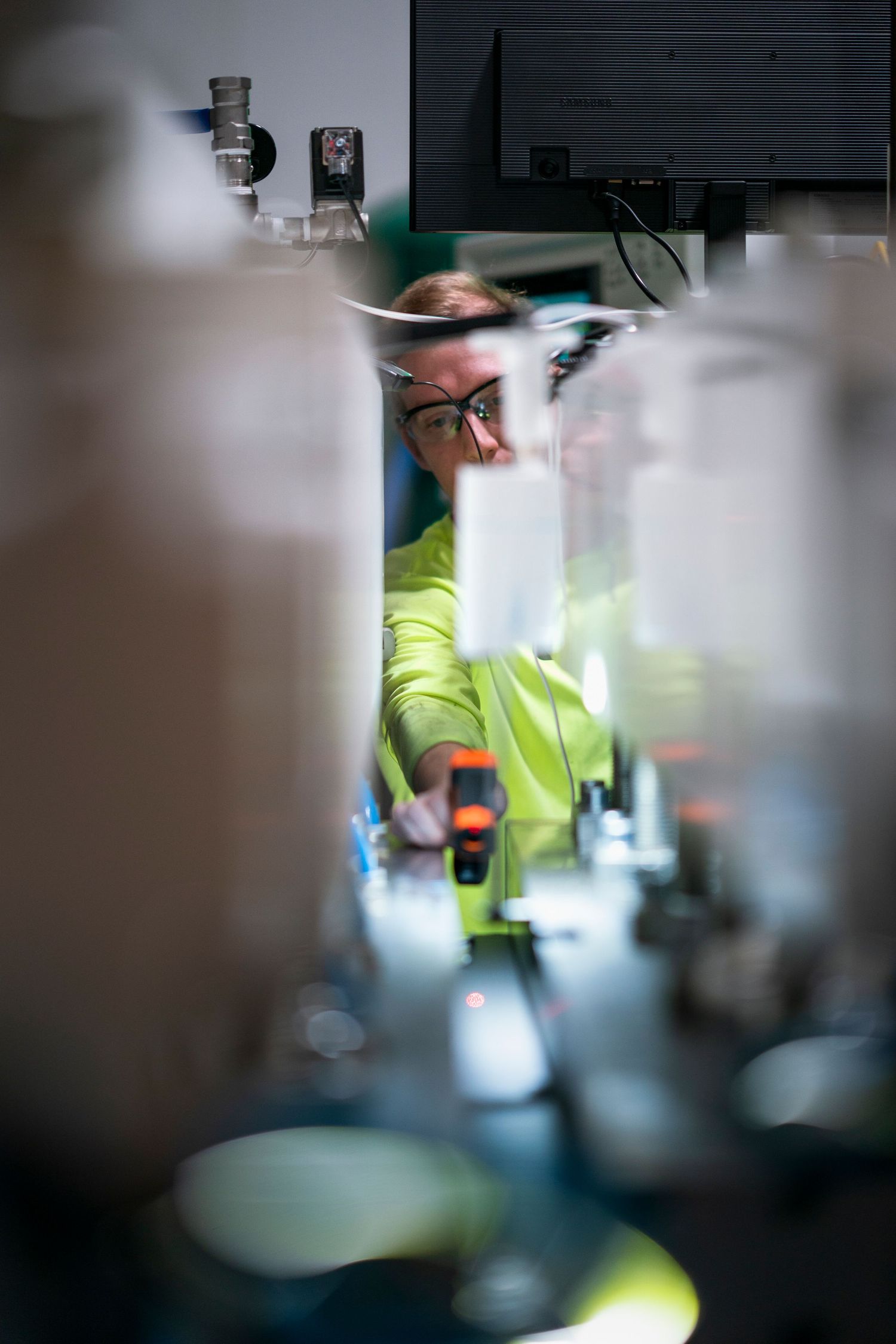 Industrial equipment photographed through machinery components with selective focus.