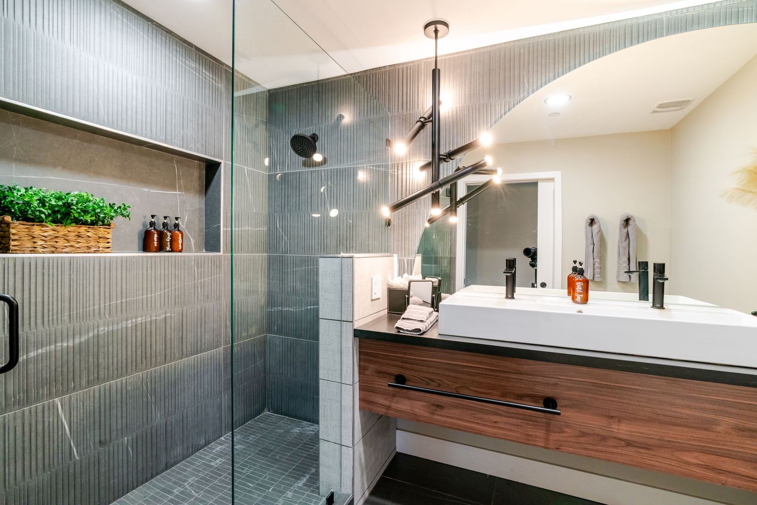 Contemporary bathroom featuring grey tile walls, wood accents, and modern fixtures with clean lines.