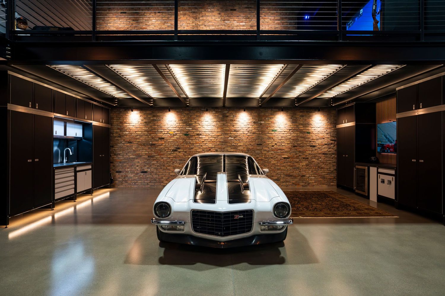 Modern luxury car parked in an upscale underground garage with exposed brick walls and dramatic lighting.