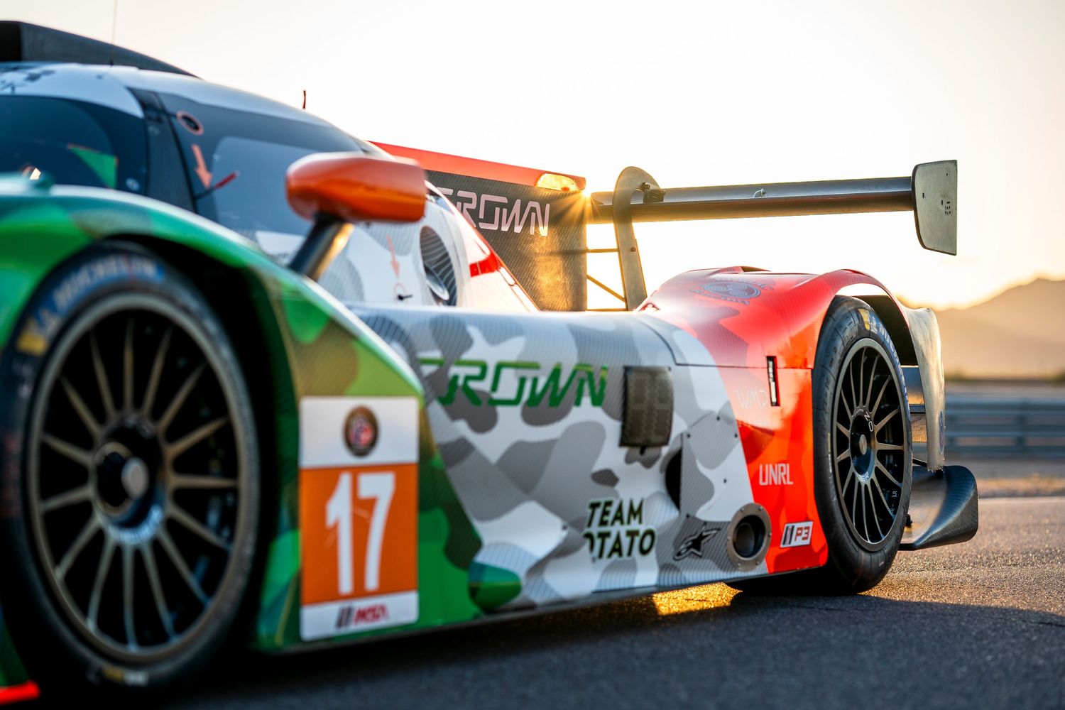 Detail shots of racing car aerodynamic elements and livery in evening light.