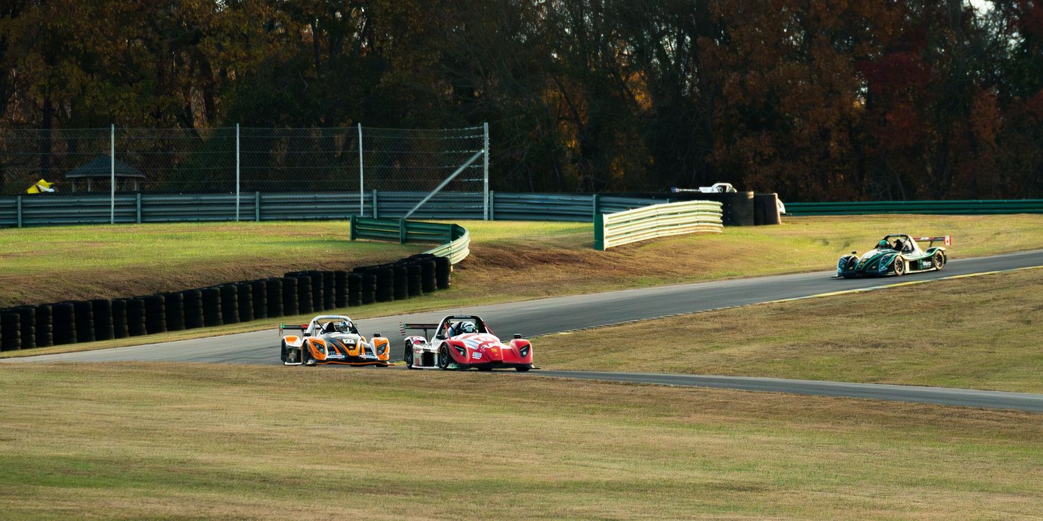 Race cars navigating through a winding track section during competition.