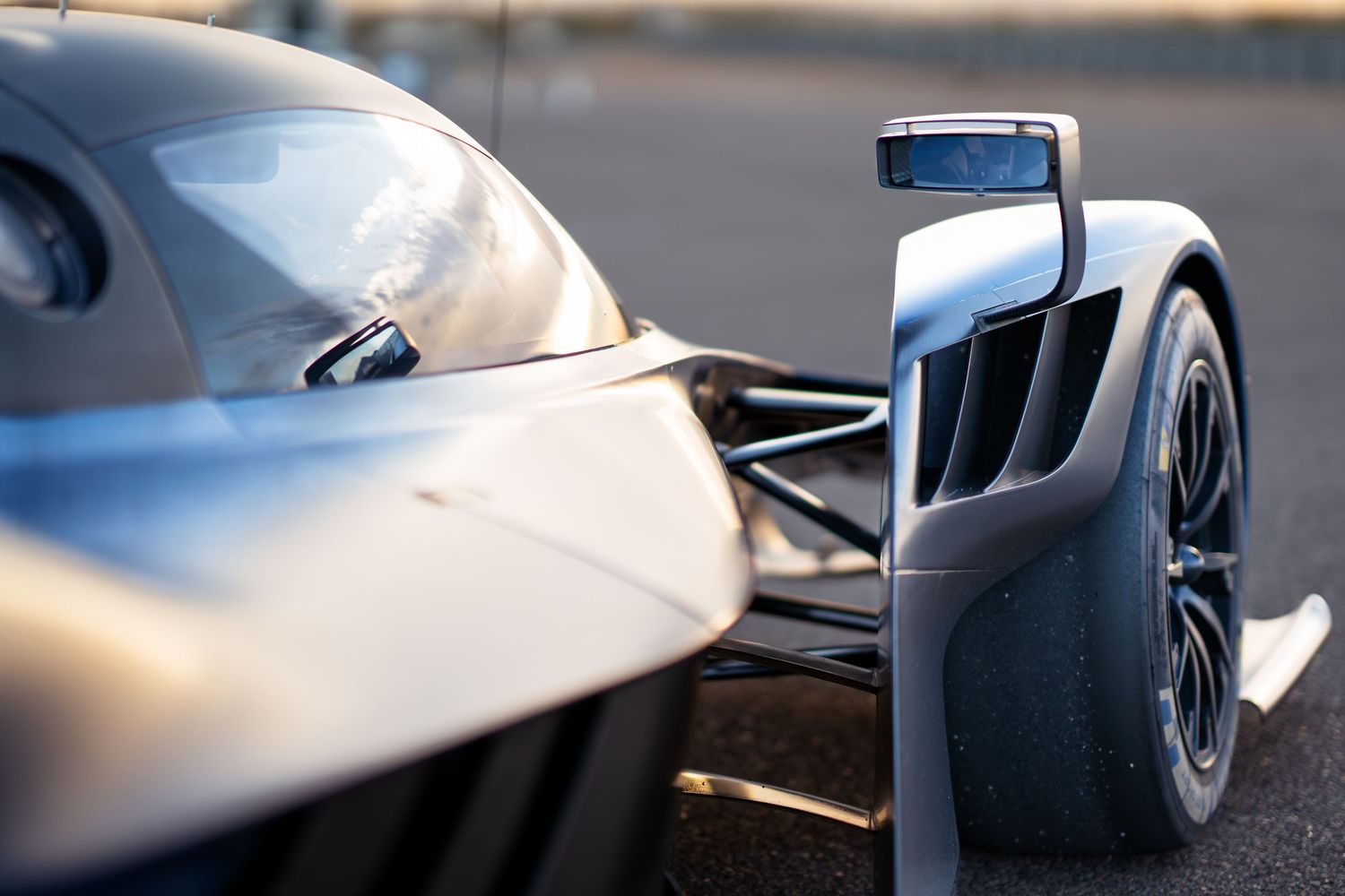 Close-up shots of silver racing car body panels showing aerodynamic details.