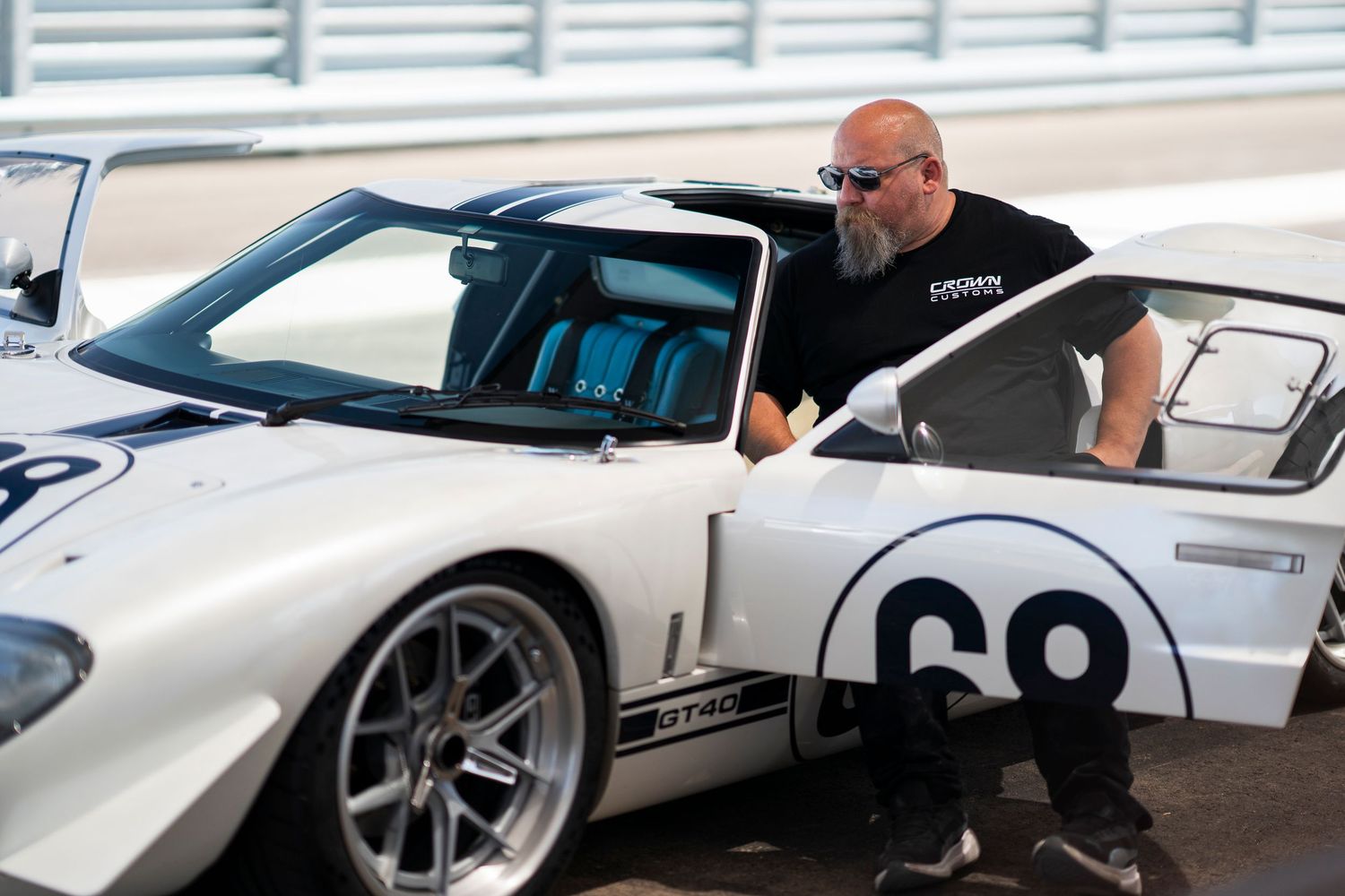 White Ford GT supercar being detailed in a professional automotive garage with bright lighting.