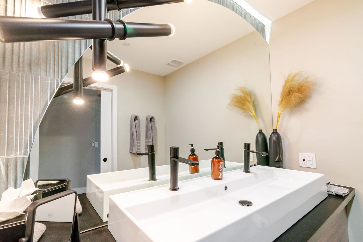 Contemporary bathroom interior with black fixtures, floating vanity, and minimalist design elements.