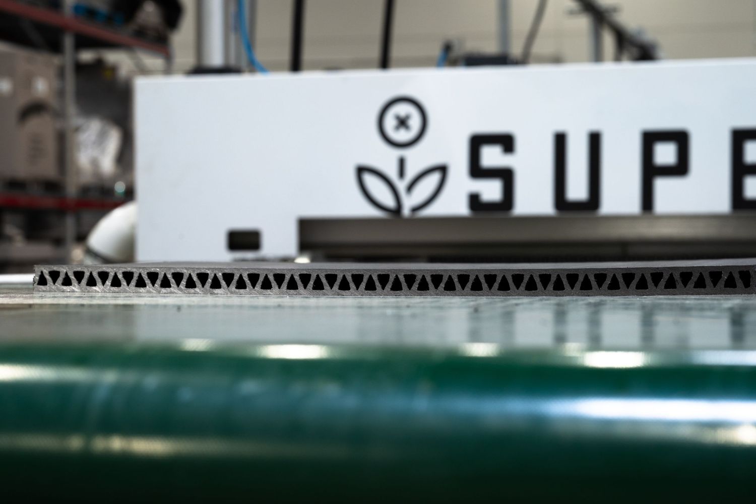 Detail shot of Supersede branding on industrial equipment with corrugated material.