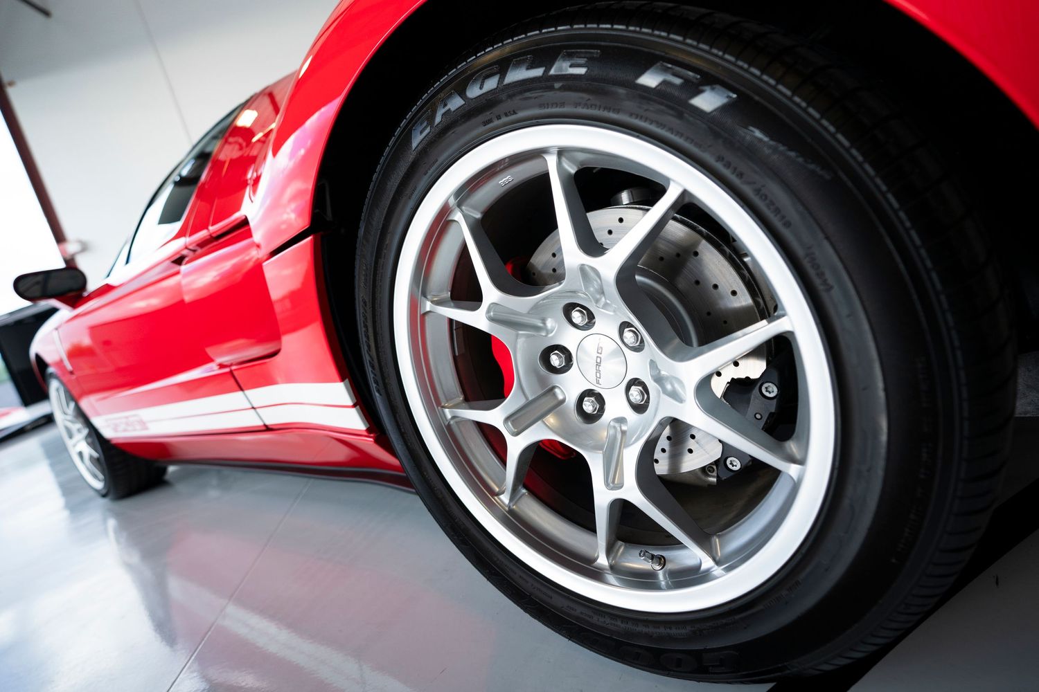 Close-up detail shots of shiny red sports car wheels and alloy rims.