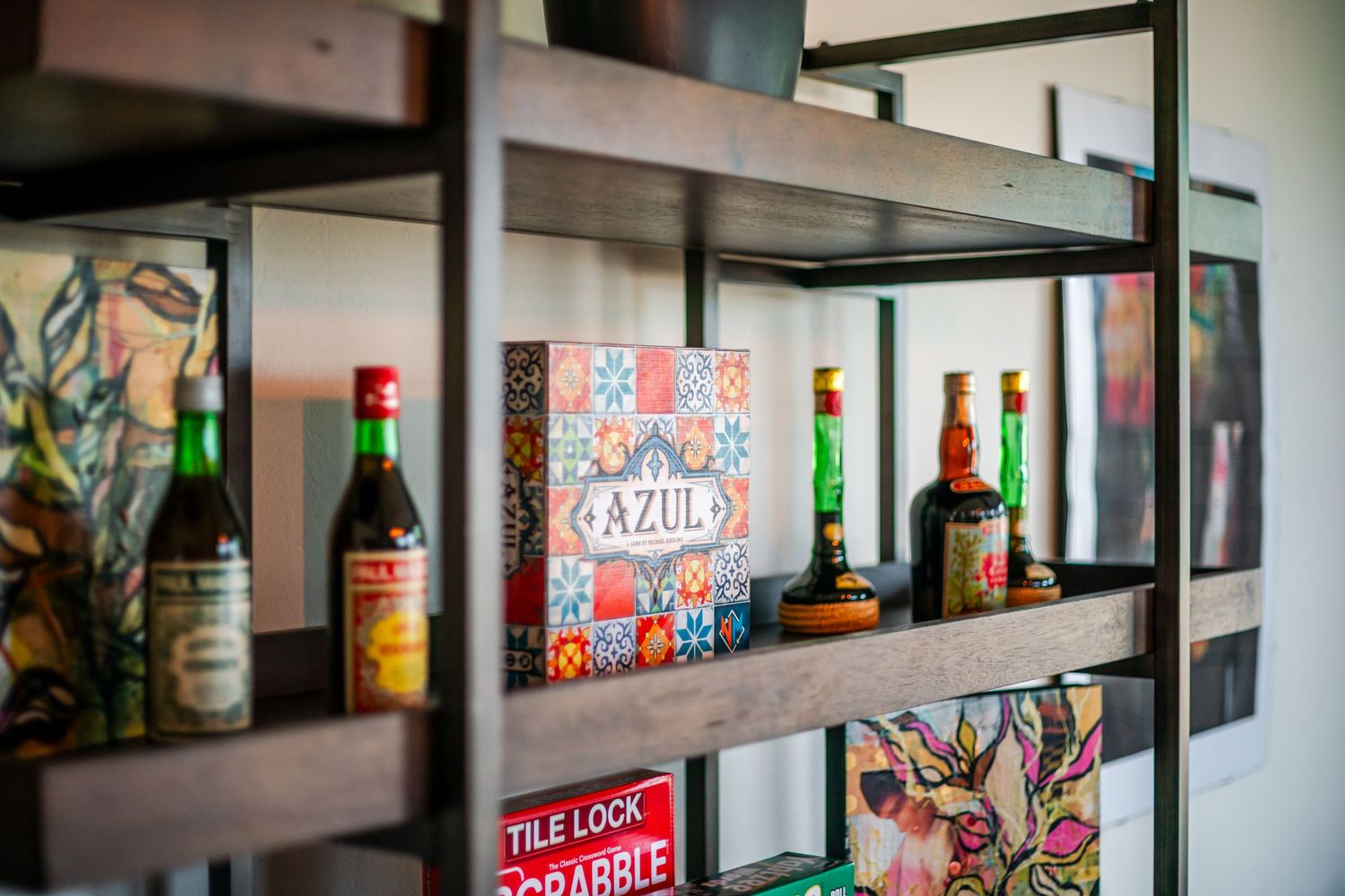 Built-in shelving unit showcasing colorful bottles, decorative items, and vintage-style signage.