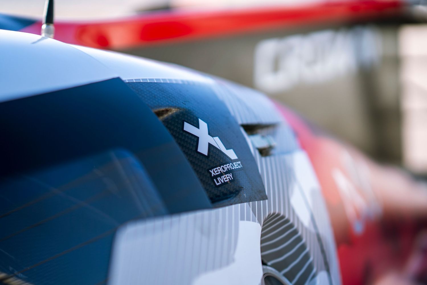 Close-up macro detail of a red and blue racing car wing showing aerodynamic design elements.