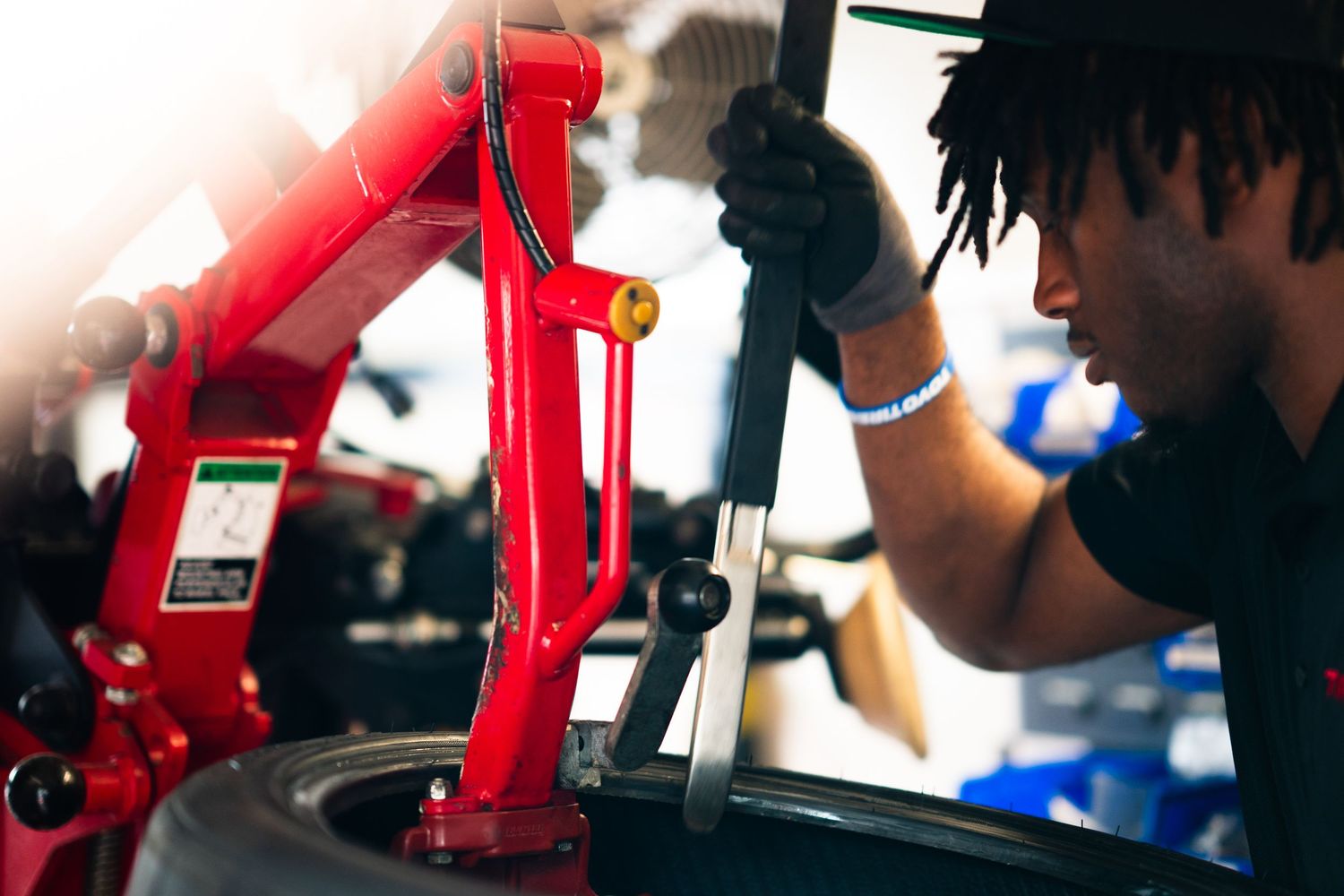 A mechanic uses a tire changing machine to mount a tire in an auto repair shop.