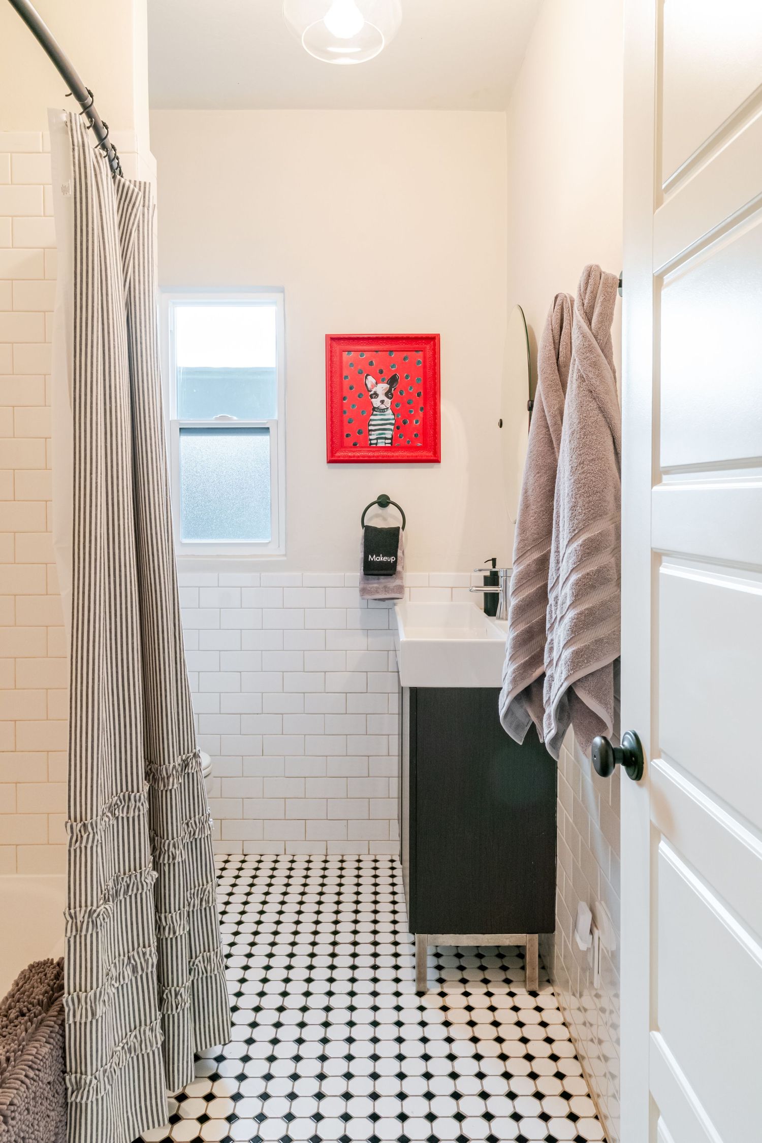 Modern bathroom interior with black and white checkered floor tiles and subway tile walls.