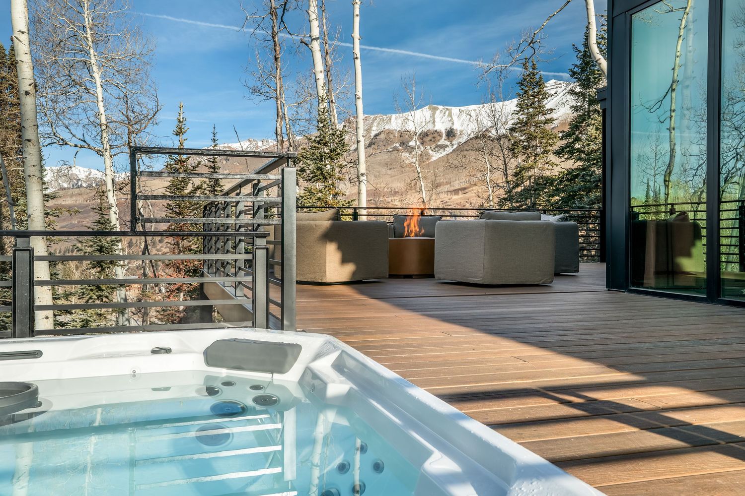 Luxury deck featuring hot tub and wooden flooring with mountain vista.