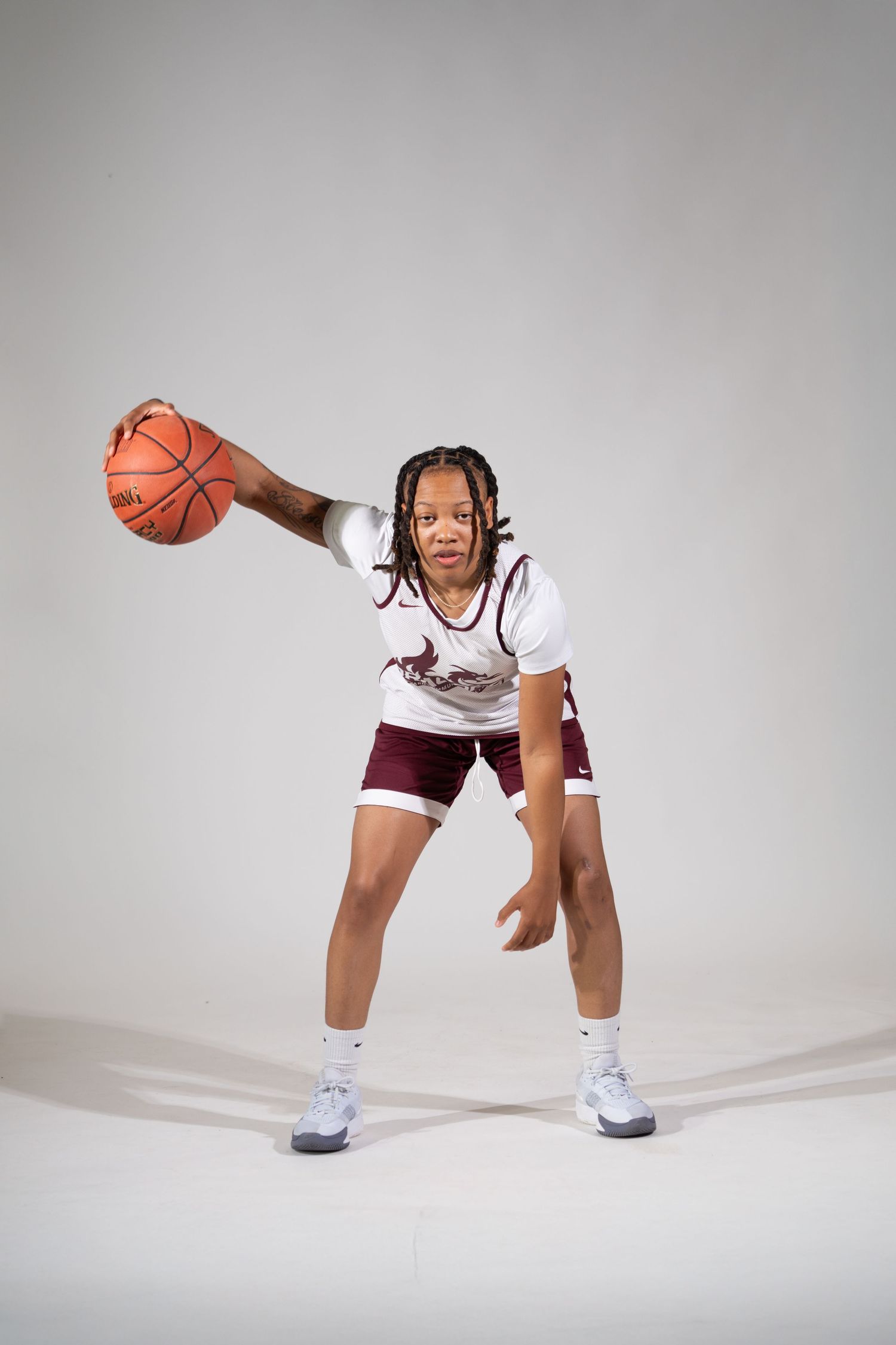 Basketball player demonstrating dribbling poses in a white uniform against grey background.