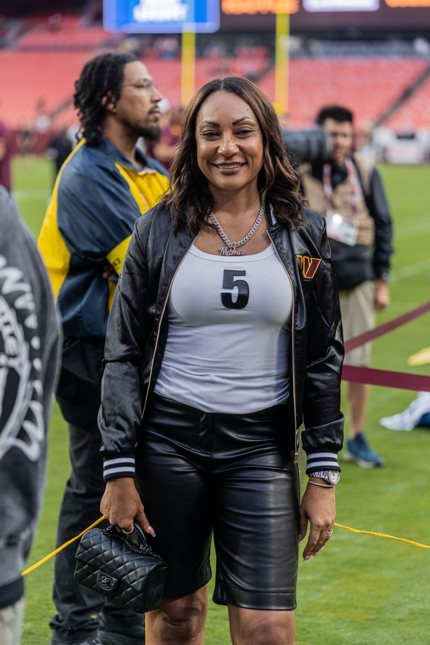 Athletes in black and white uniforms gather on sports field during game day.