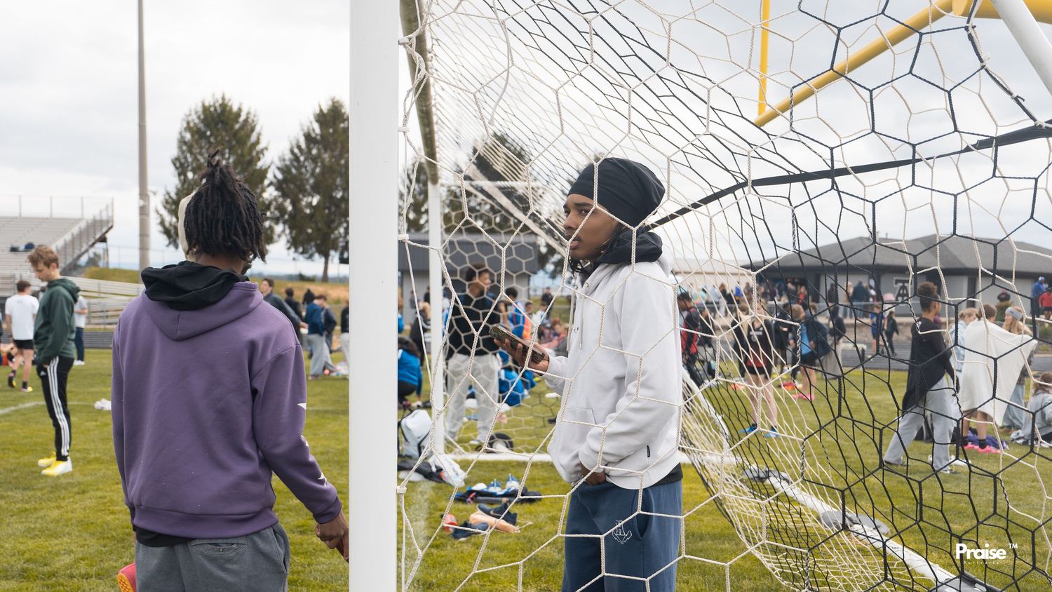 Athletes practicing near soccer goal nets during an outdoor training session.