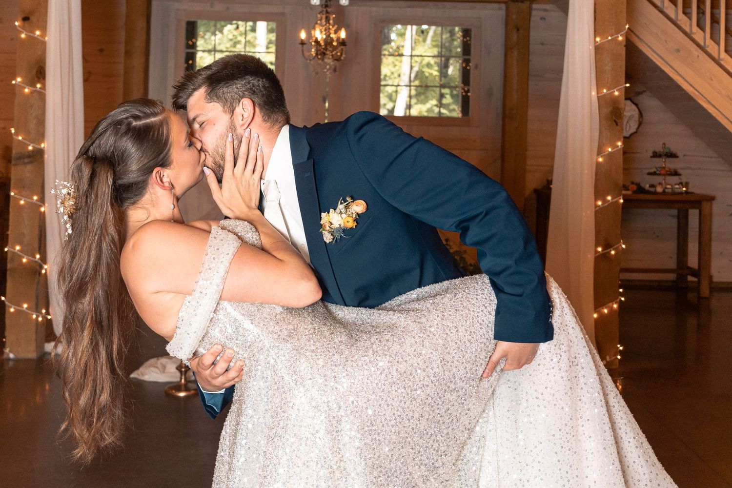 Wedding couple performing romantic dance dip in venue with twinkle lights.
