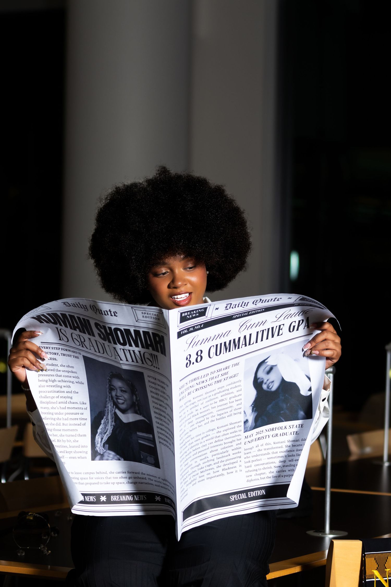 Person with afro hairstyle reading a newspaper with an engaged expression.