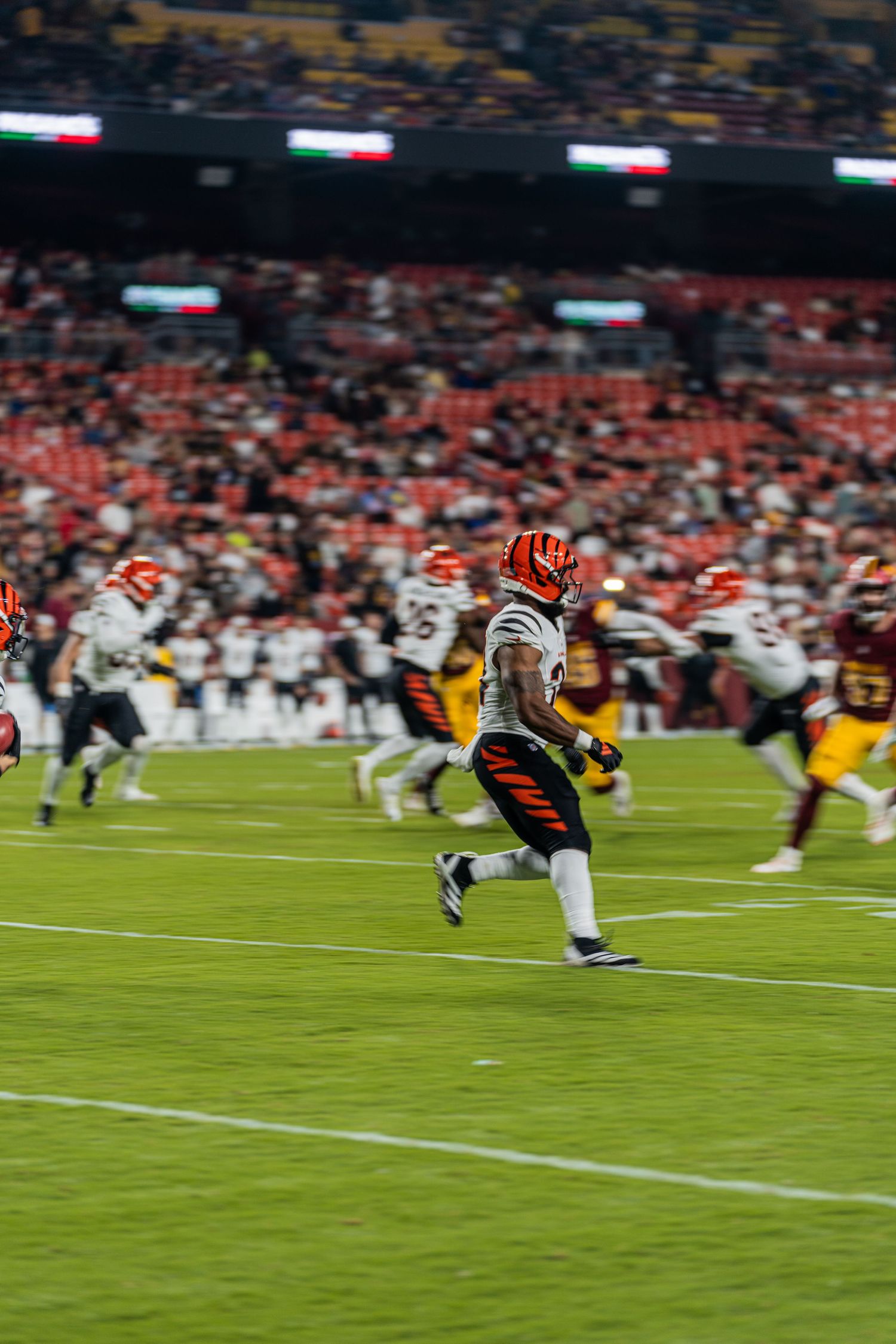 Football players sprint across the field during an intense game play.