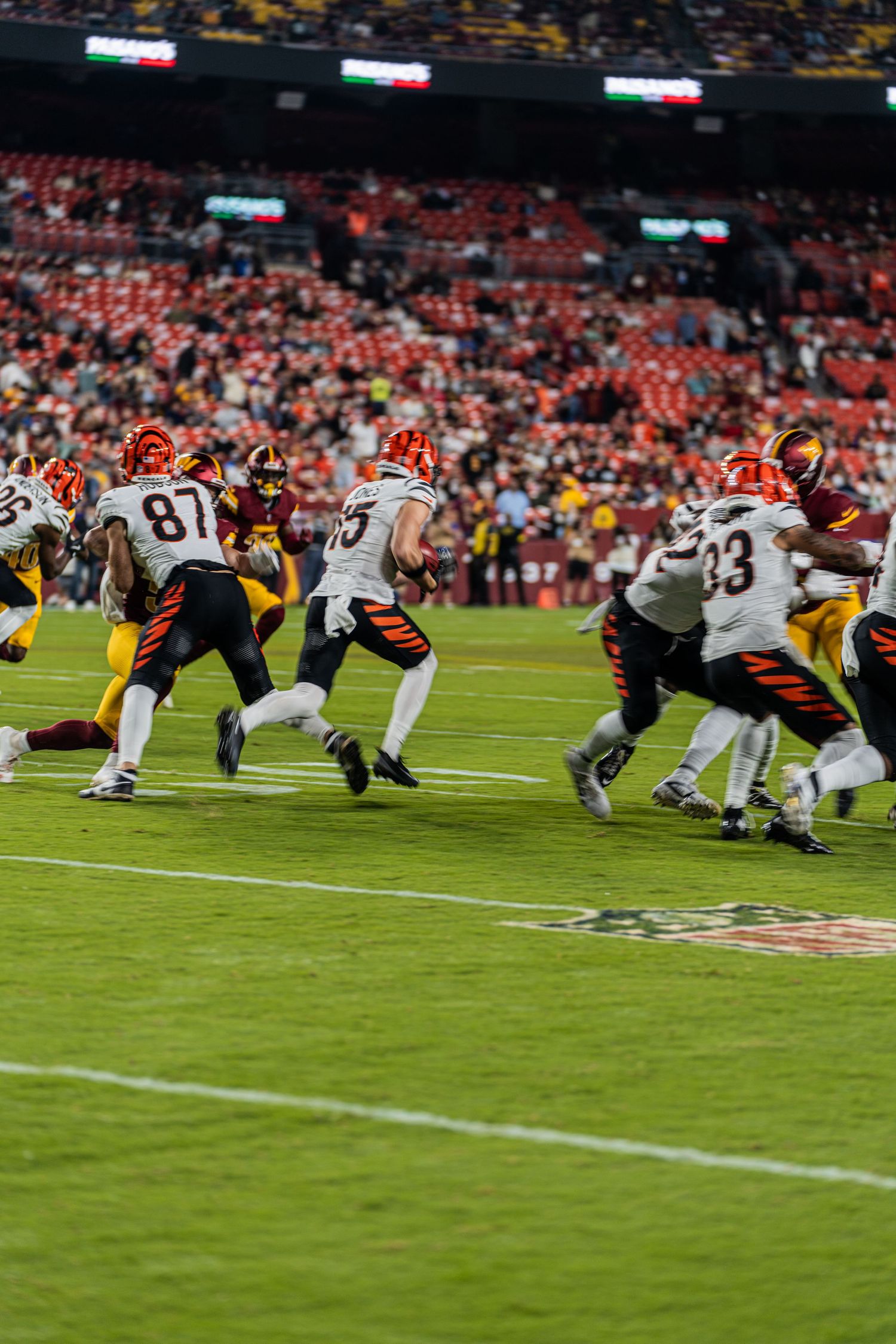 Football teams face off at the line of scrimmage during an intense game play.
