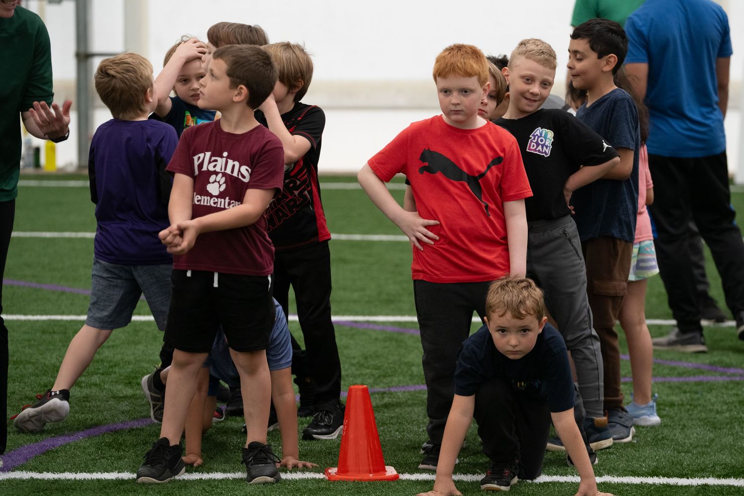 Children participating in outdoor physical activities on a sports field.