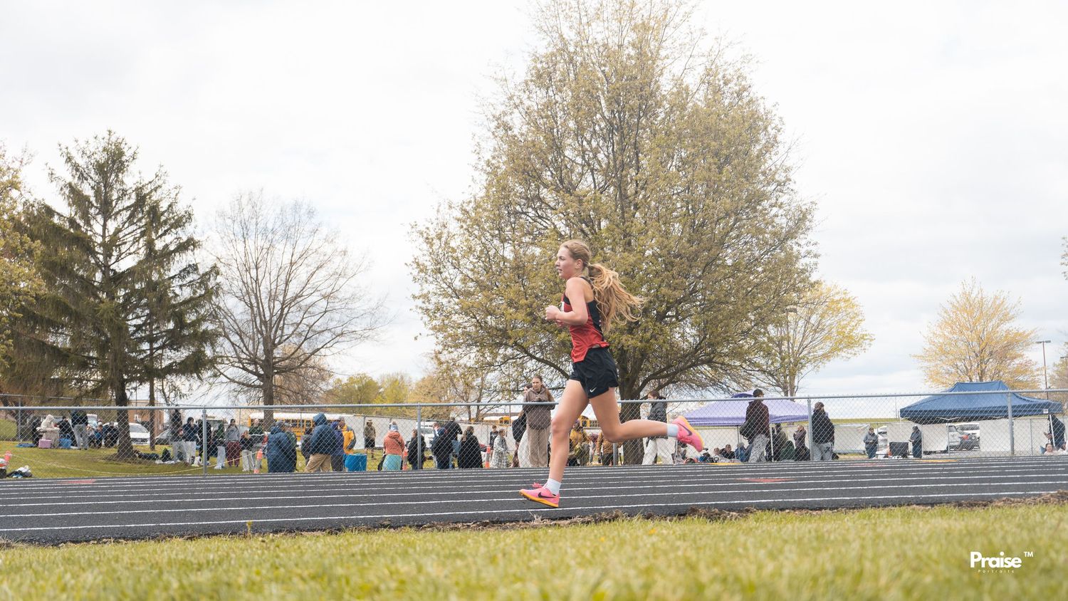 Panoramic view of a track and field event with spectators lined up along the course.