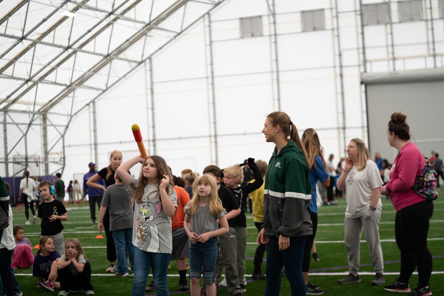 Interior view of a large sports dome with people gathered for an event.