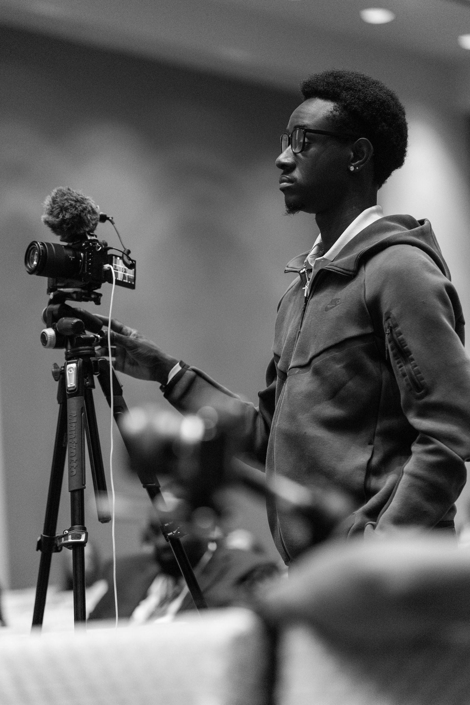 Row of photographers with tripods and cameras at a professional event.